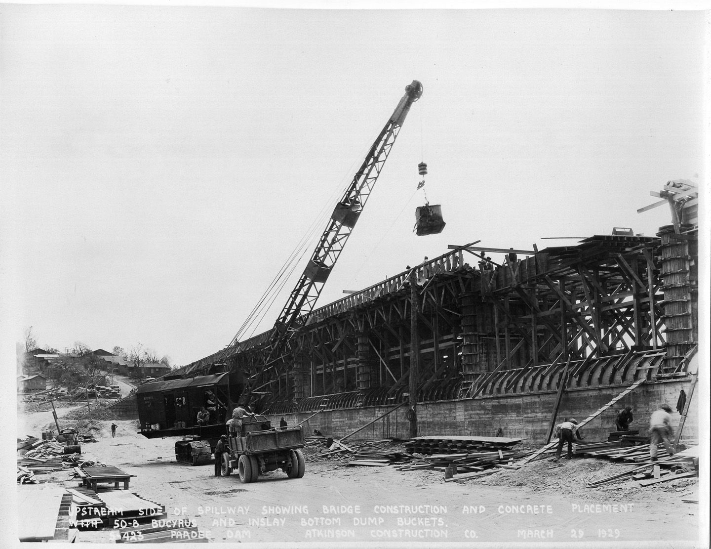 Upstream side of spillway showing bridge construction and concrete placement with 50-8 Bucyrus and inslay bottom dump buckets. (March 1929)	