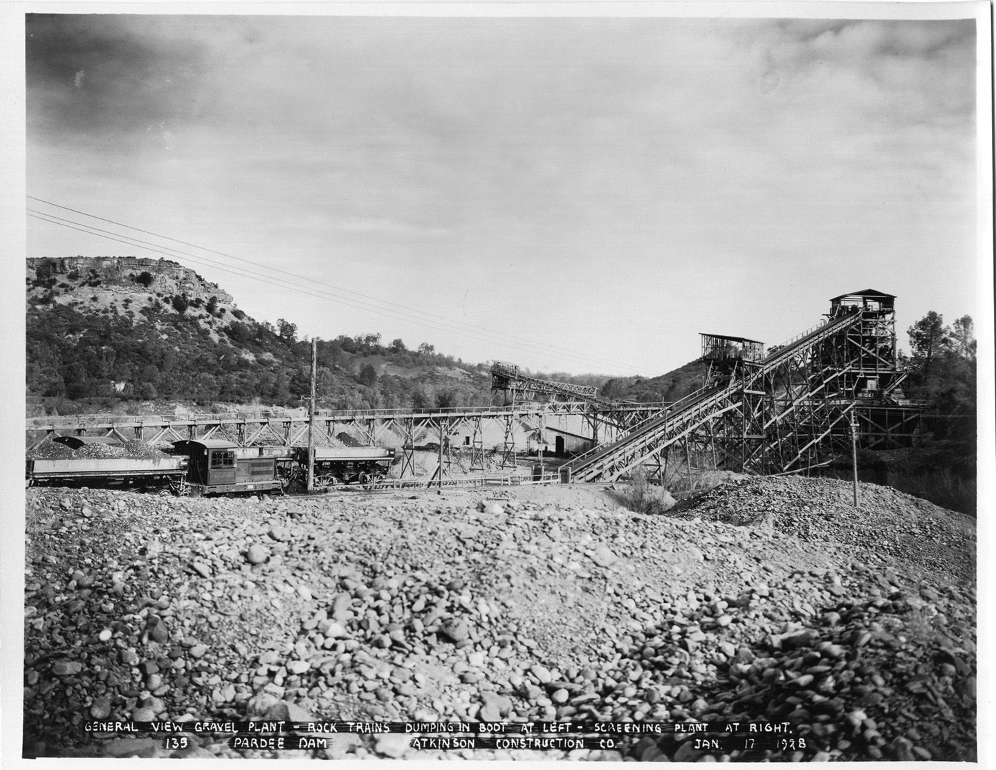 General view gravel plant - rock trains dumping in boot at left - screening plant at right. (January 1928)