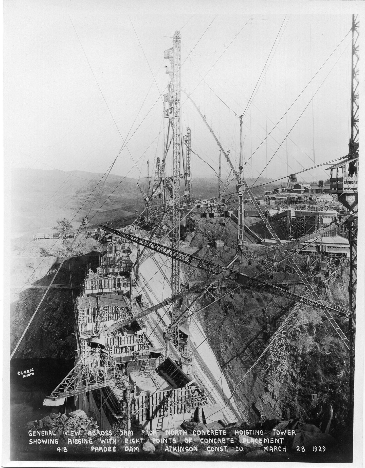 General view across damn from north concrete hoisting tower showing rigging with eight points of concrete placement. (March 1929)	