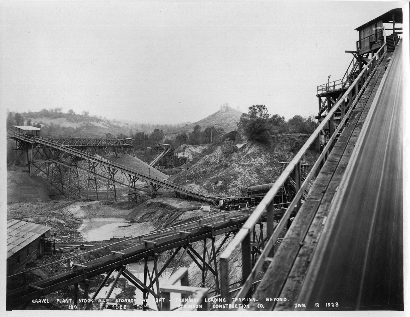 Gravel plant stockpile storage at left - tramway loading terminal beyond. (January 1928)