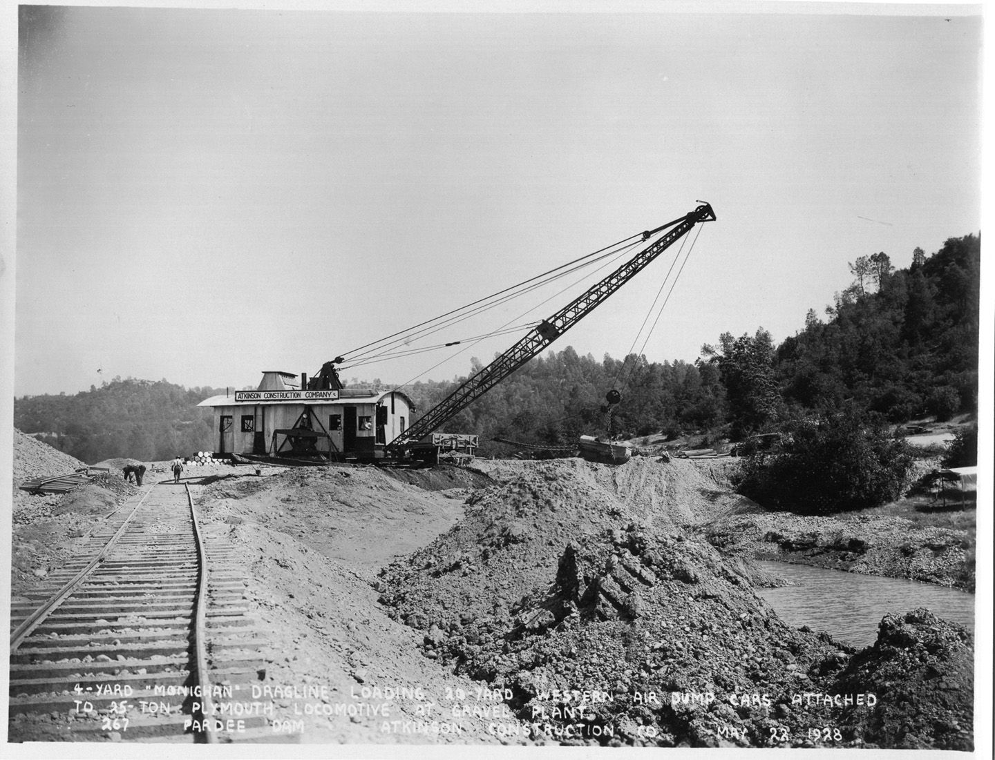 4-yard dragline loading 20 yard western air dump cars attached to 25-ton Plymouth locomotive at gravel plant. (May 1928)