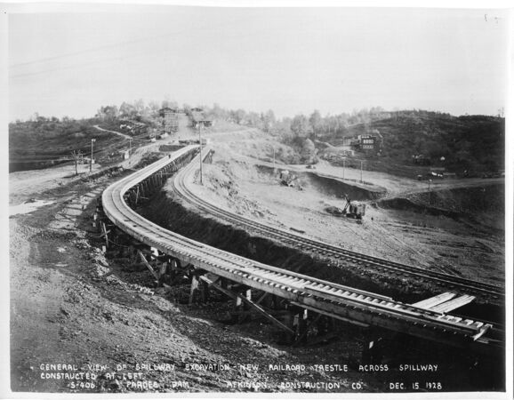 General view of spillway excavation - new railroad trestle across spillway constructed at left. (December 1928)	
