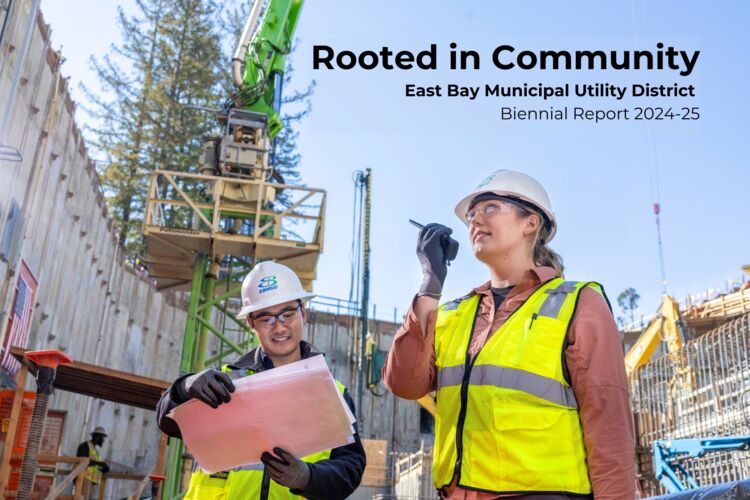 Photo of two construction engineers in construction vests looking out from a large pit of construction.