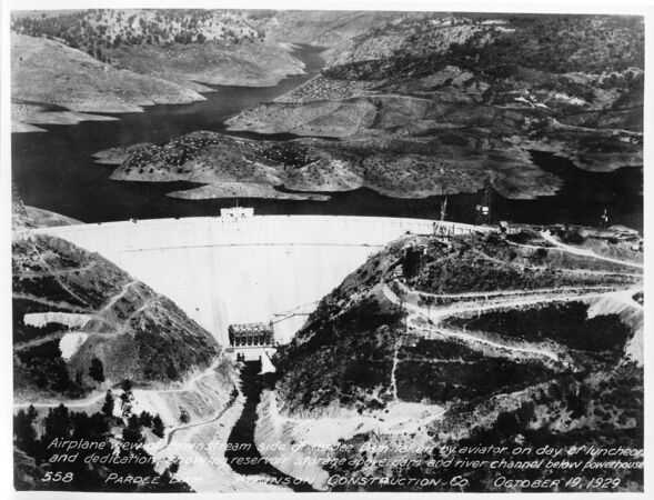 Airplane view of downstream side of Pardee Dam taken by aviator on day of luncheon and dedication, showing reservoir storage above dam and river channel below powerhouse. (October 1929)	