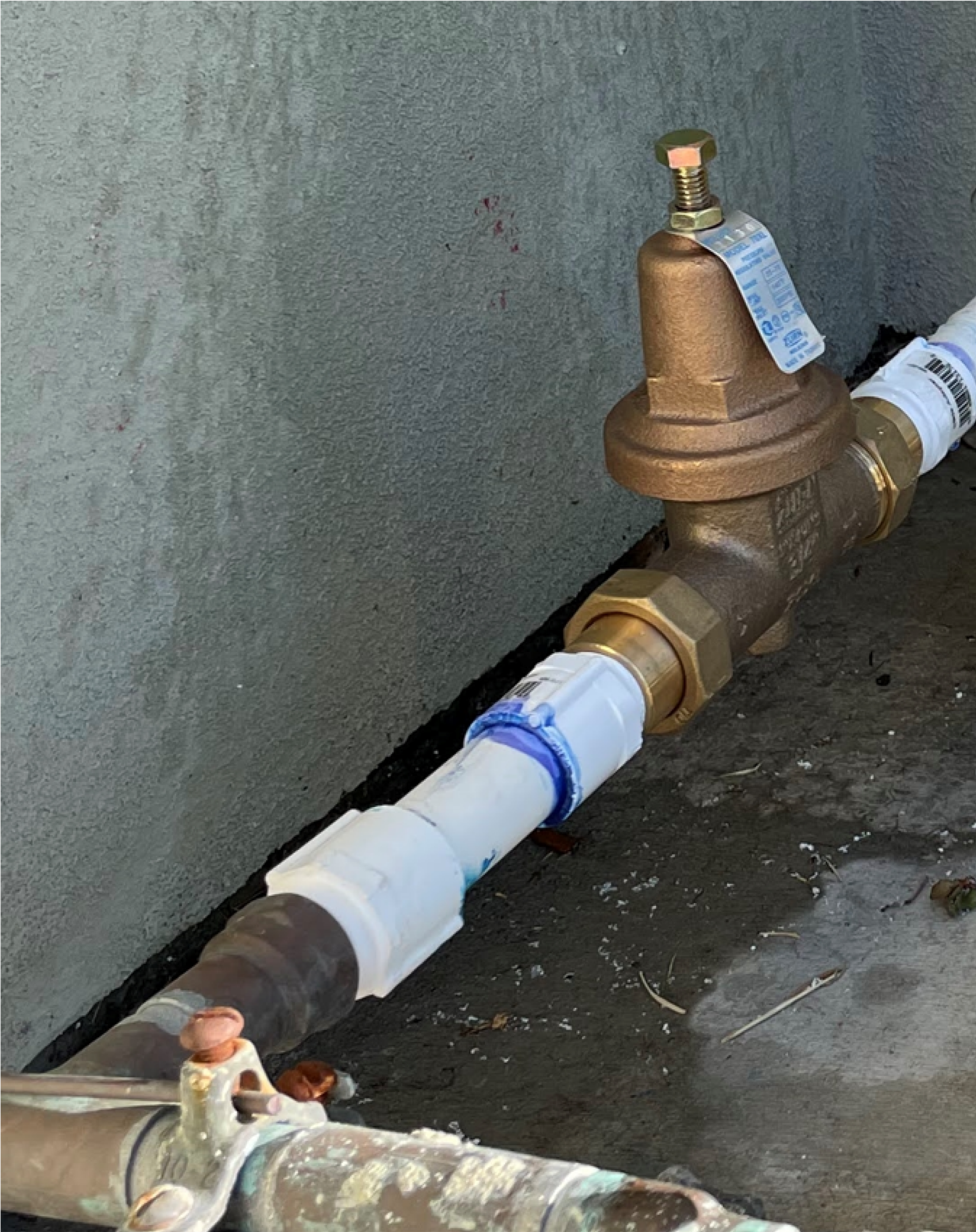 Photo of newly installed brass or bronze pressure regulator installed upstream of the entire irrigation system.